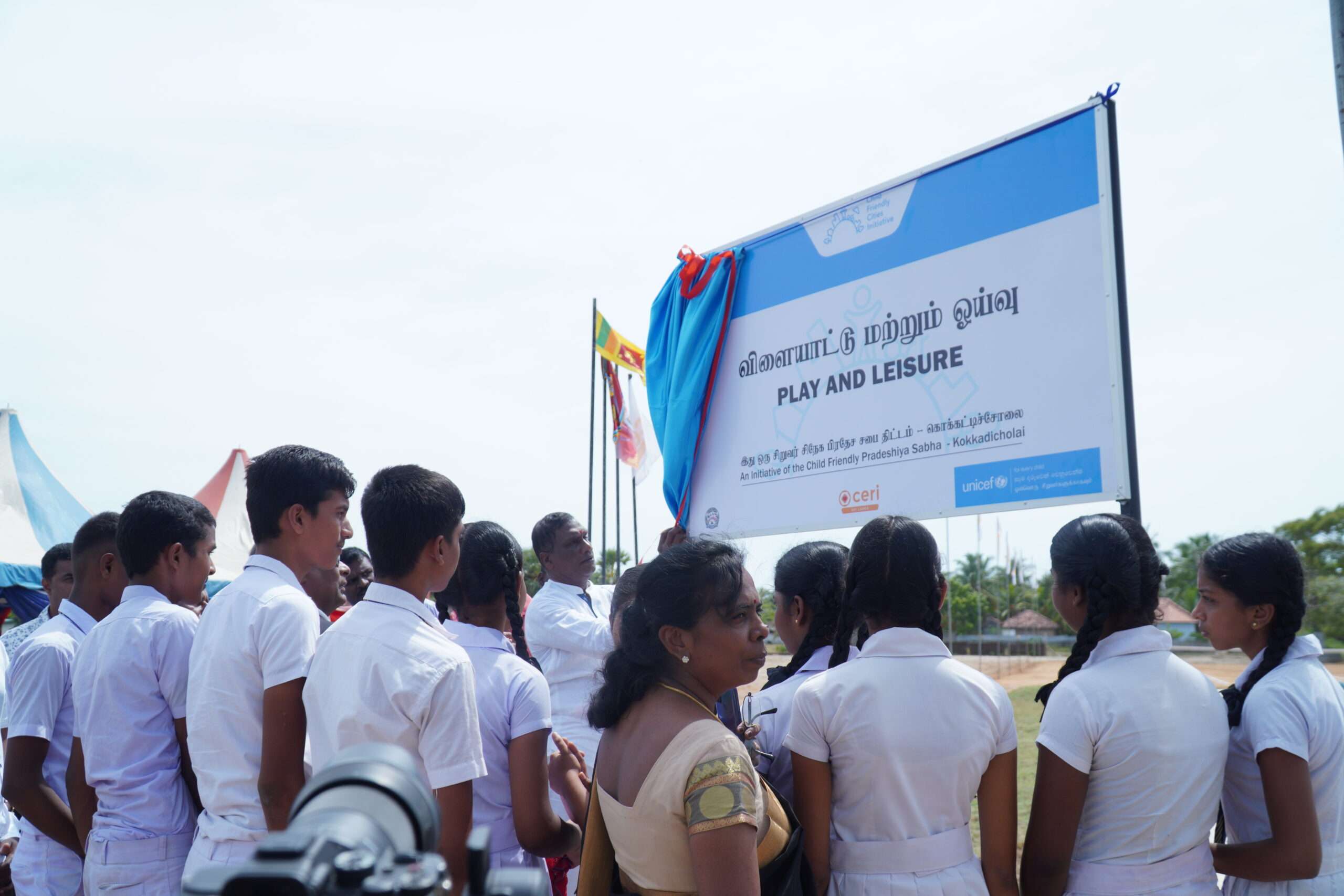 People stand to view revealing of sign